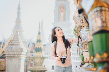 Fototapeta na wymiar Asian women travel with camera sightseeing in temple in Thailand