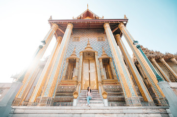 wide angle shot of happy Asian women travel sitting and enjoy looking at temple in Thailand