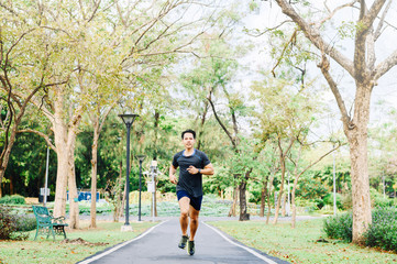 Happy Asian man running in the park in morning