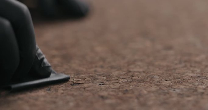 Slow motion man hands in black gloves sand dark cork surface