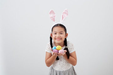 Obraz na płótnie Canvas little child girl with easter bunny ears holding egg