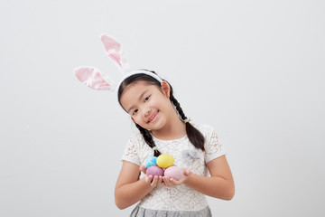 little child girl with easter bunny ears holding egg
