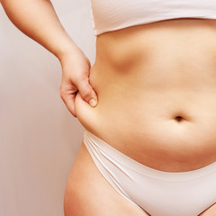 Fat unhealthy woman body. Pinch belly side. Measurement lady procedure. Medicine pinching. Anti cellulite overweight.