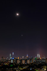 Night view over downtown Kuala Lumpur with crescent Moon and Venus as part of the night. 