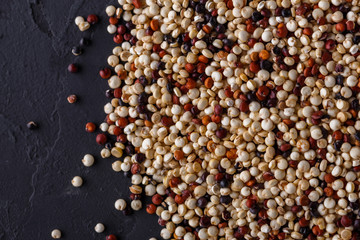 mix of quinoa grains on a dark stone background