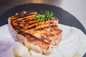 Grilled pork loin with tomatoes, pita bread and spices. On a beautiful black tray. Tasty food.