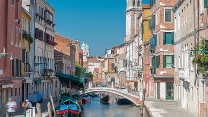 Fototapeta na wymiar A view of Venice timelapse: canal, bridge, boats and an old tower in the background