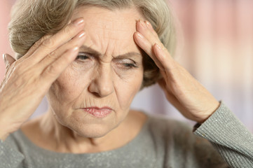 Portrait of beautiful senior woman with headache