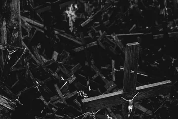 Foto auf Leinwand Old wooden crucifix against a heap of other ones. Symbool of christianity, faith, death. Dark spooky concept. Black and white © Yurii Zymovin