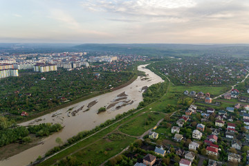Fototapeta premium Aerial view of Ivano-Frankivsk city with residential area and suburb houses with a river in middle.