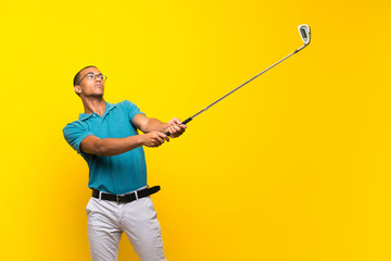 Afro American golfer player man over isolated yellow background
