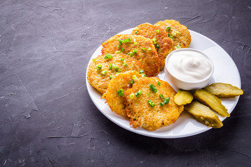 Delicious crispy potato pancakes on dark stone background