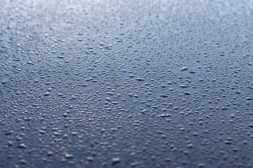 Blue metal surface covered with water droplets.