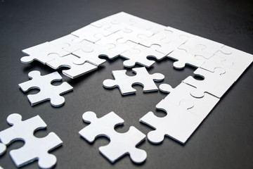 White puzzles on a black background close-up