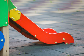 Part of new colorful playground slides on soft flooring background.