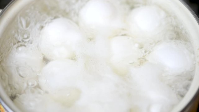 Top view close-up of chicken eggs boiled in a pan in the kitchen on the stove. Cooking food.