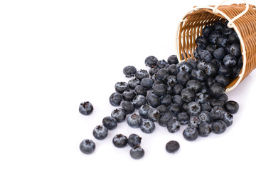 Fresh organic black blueberries in wooden basket isolated on white background. 