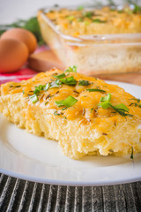 Delicious potato casserole with egg and cheese on a gray wooden background