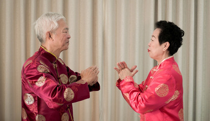 Asian senior couple celebrate Chinese new year in red traditional costume