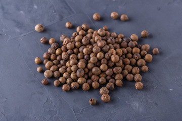 fresh spicy peppers allspice on a dark stone background