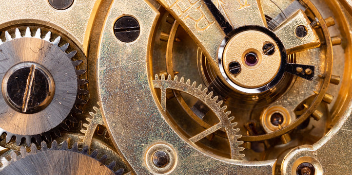 Close up of an authentic 100 hundred years old pocket watch mechanism cogs and wheels , golden, pendulum, jewels strip_