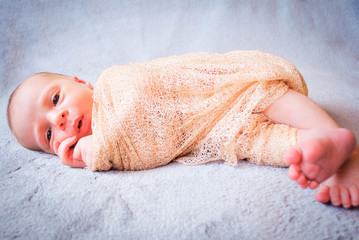Bebe newborn arropado despierto de costado