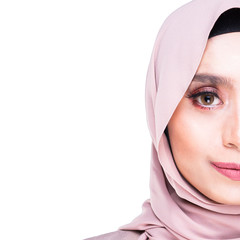 A half faced headshot portrait of an attractive Muslim lady wearing hijab isolated on a white background. Square format. Copy space on left.