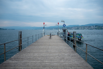 Obraz premium Empty dock with ferry boat at Limmat river with cloudy sky , background , copy space , Zurich , Switzerland