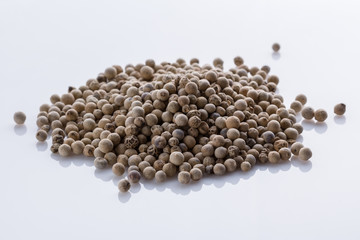 white peppercorns seed on white acrylic background