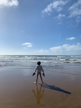 Ni&ntilde;o moj&aacute;ndose los pies en la orilla del mar
