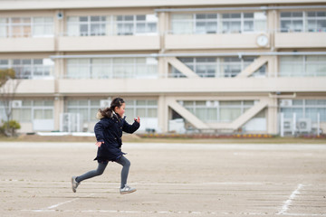 Fototapeta na wymiar 校庭で走る女の子