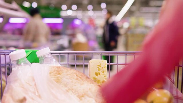 Food in a trolley on the background of the supermarket