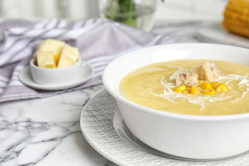 Delicious corn cream soup served on white marble table, closeup. Space for text