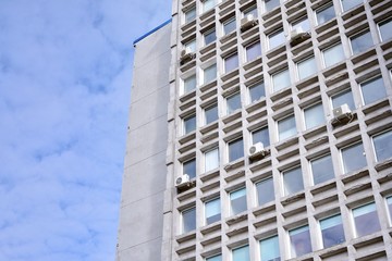 Facade of an old industrial office building with a predominance of old cement and old structural elements.