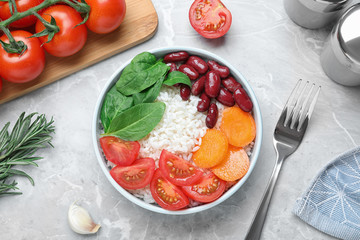 Tasty rice with beans served on light grey marble table, flat lay