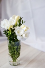 white freesia flowers in a glass