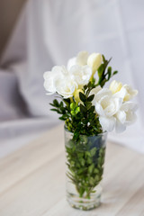 white freesia flowers in a glass