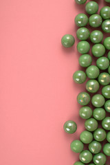 Green pastel marbles at soft pink background. Creative minimal concept.