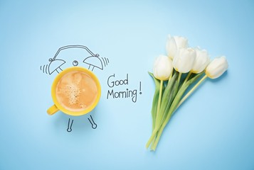 Flat lay composition with good morning wish and aromatic coffee on light blue background
