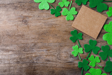 Flat lay composition with clover leaves on wooden table, space for text. St. Patrick's Day celebration