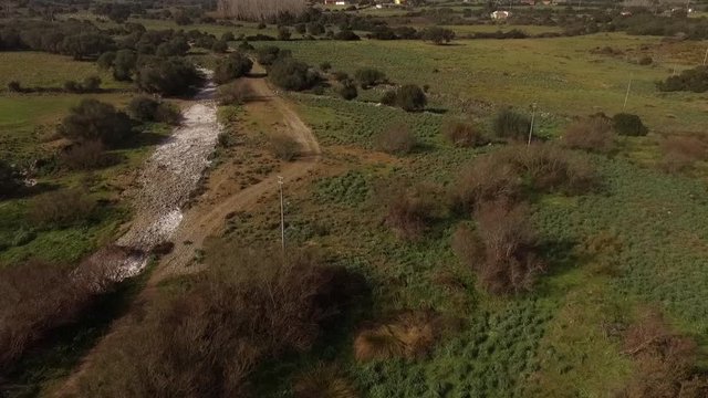 aerial view of the overflight of the lake and coghinas river in sardinia wrapped in trees and agricultural fields with the drone