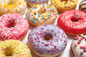 Delicious glazed donuts on white background, closeup