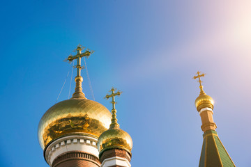Fototapeta na wymiar Three domes of the Orthodox Church against the blue sky. Religion, traditional architecture.