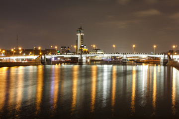 Fototapeta na wymiar Night view of the Novospassky bridge, the reflection of city lights in the river.