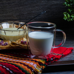 Maslenitsa: thin pancakes with berries and a glass of milk on a wooden table. Delicious breakfast.
