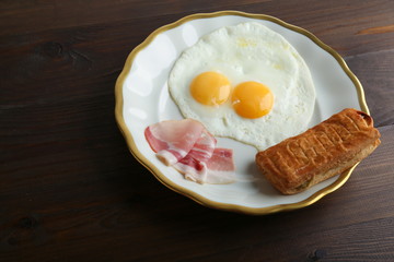 fried eggs is on the plate on dark wooden background