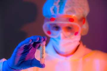 Frau untersucht Laborprobe Covid-19