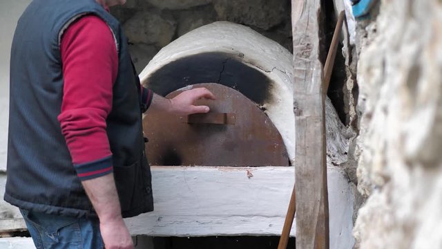 The Baker put the flatbread to bake and closed the iron door of the stove