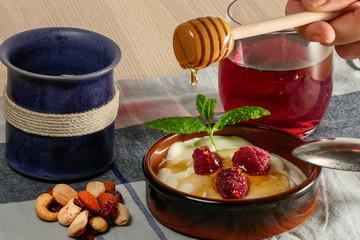 A plate of  Turkish yogurt with berries, mint, avocado, and a glass of juice.