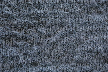 Gray knitted background. Close up gray fabric texture background. wrinkled and shadows, selective focus top view